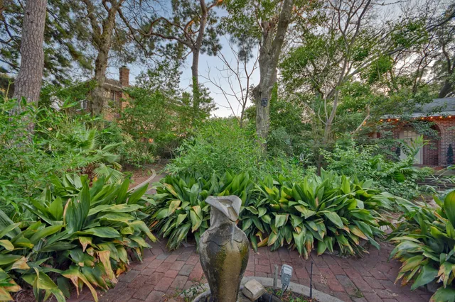 a backyard of a house with lots of green space and a fountain