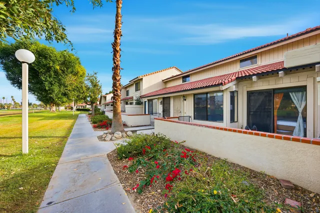 a front view of a house with a garden and trees