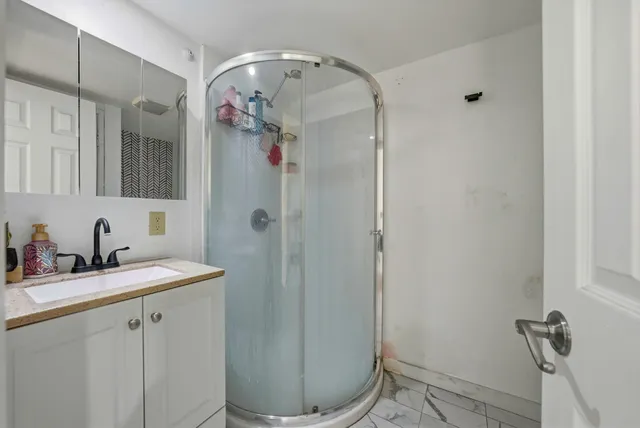 a bathroom with a sink a toilet and shower