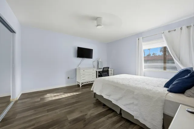 a bedroom with a bed and a flat tv screen on dresser