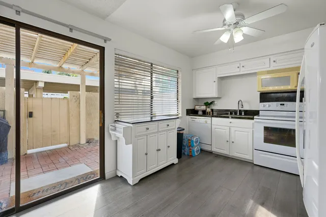 a kitchen with white cabinets and white appliances