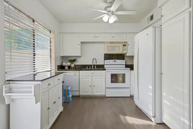 a kitchen with white cabinets and white appliances