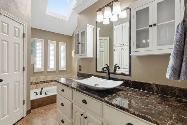 a bathroom with a granite countertop sink and a mirror