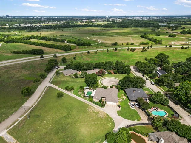 an aerial view of a house with swimming pool and garden