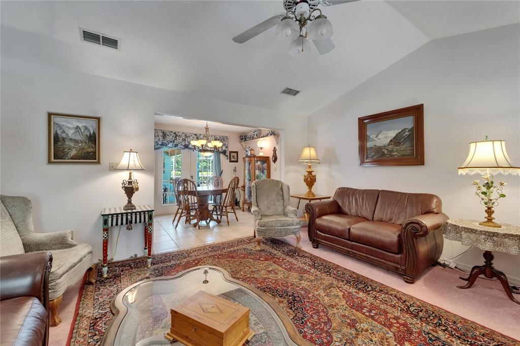 11120 Lu Wista Road Brooksville, FL 34601 - Photo 17 of 50 a living room with furniture a chandelier and a flat screen tv