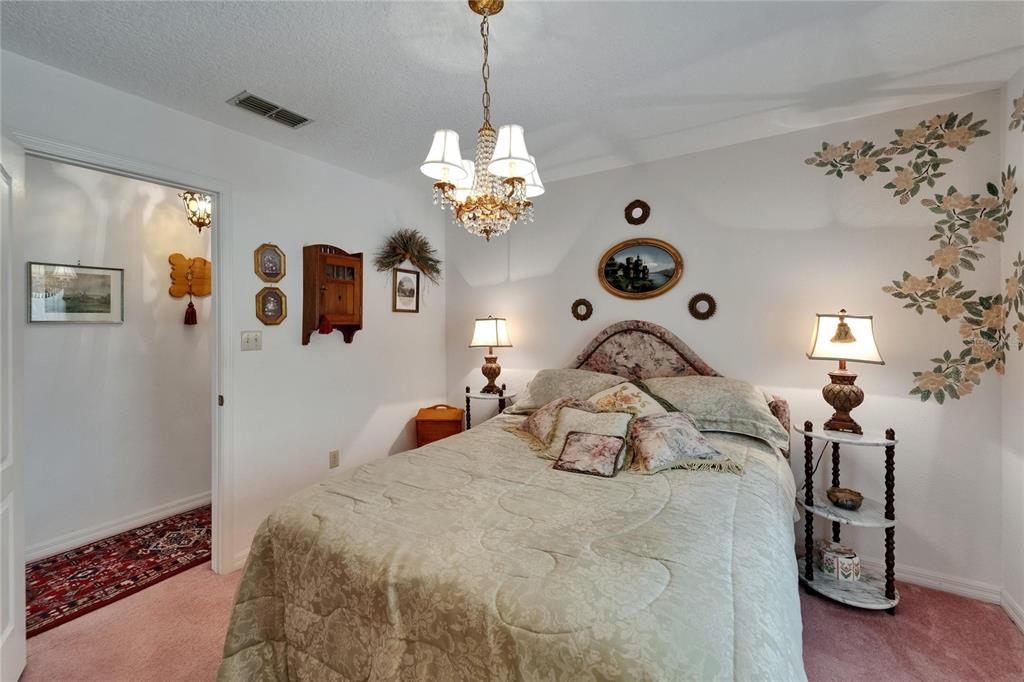 11120 Lu Wista Road Brooksville, FL 34601 - Photo 24 of 50 a bedroom with a bed and a chandelier