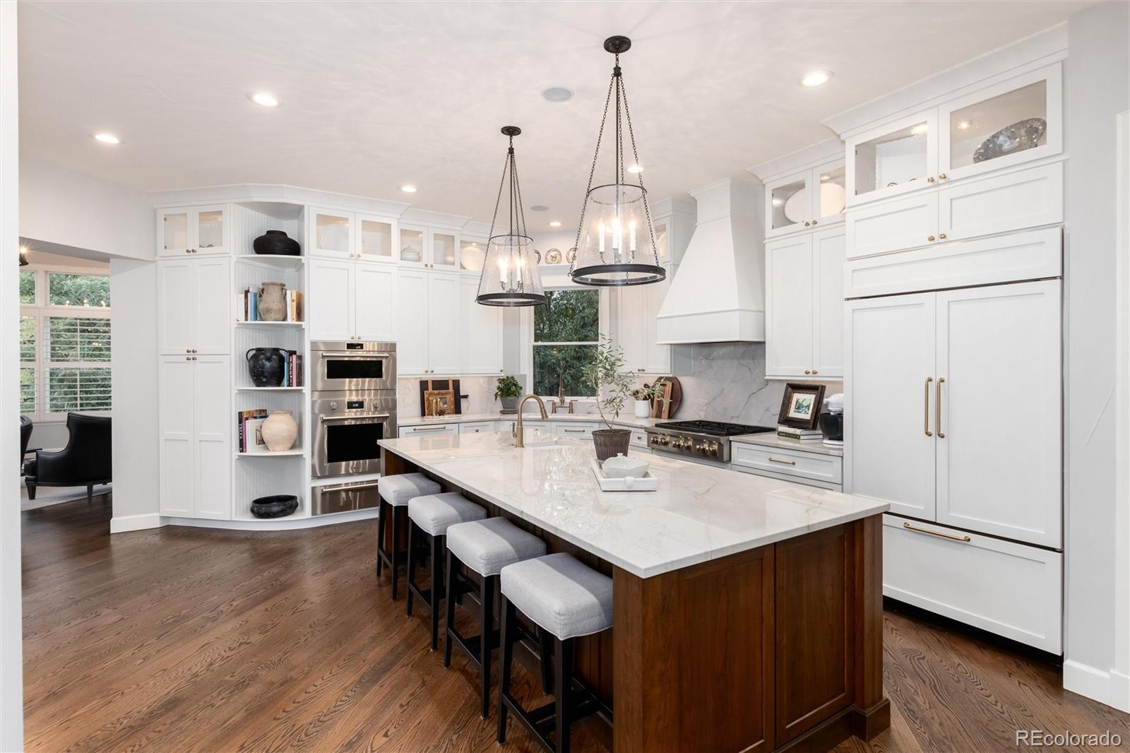 7175 Polo Ridge Drive Littleton, CO 80128 - Photo 9 of 50 a kitchen with stainless steel appliances a refrigerator a sink dishwasher a stove and white cabinets with wooden floor