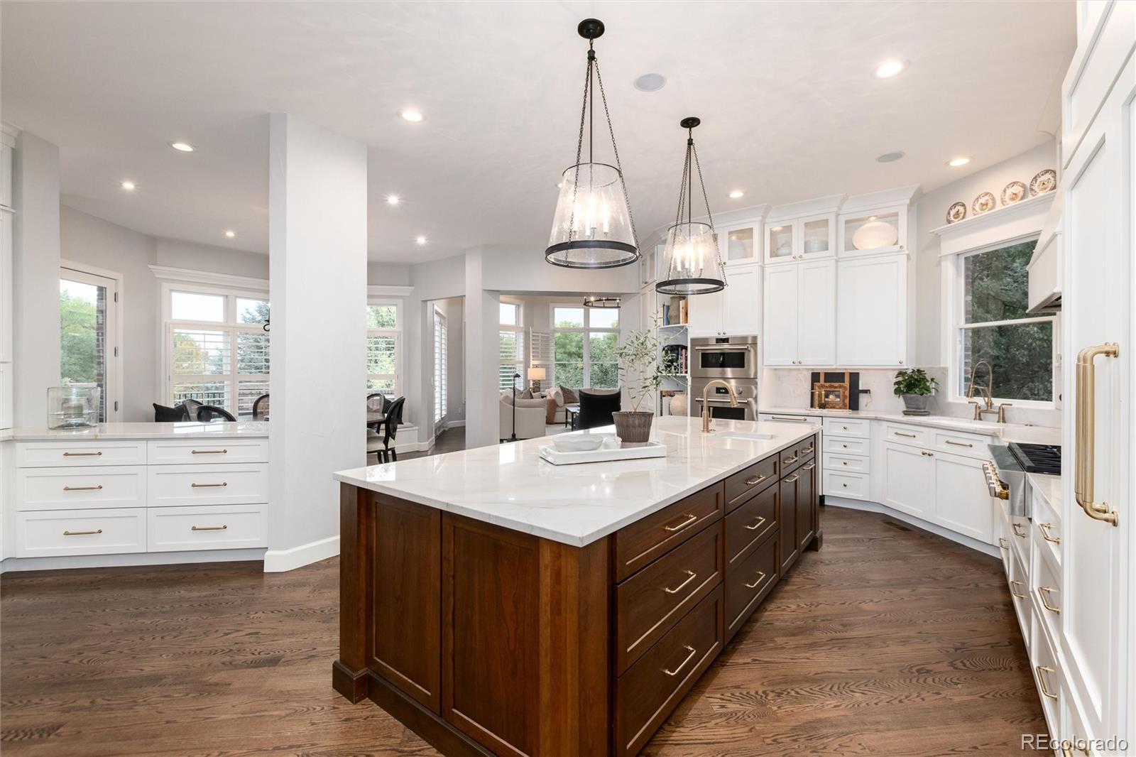 7175 Polo Ridge Drive Littleton, CO 80128 - Photo 10 of 50 a large kitchen with kitchen island a stove a sink a center island and a wooden floor