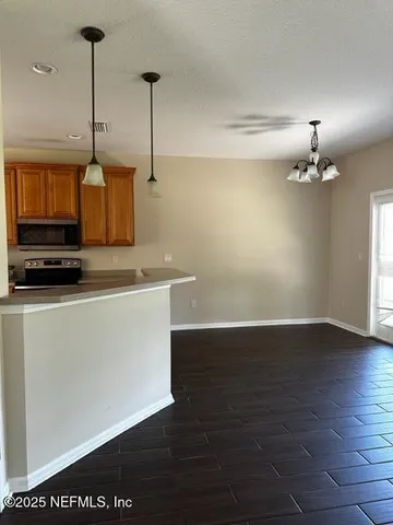 a kitchen with granite countertop a stove a sink and a wooden floor