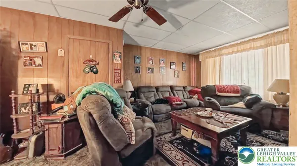 a living room with furniture a flat screen tv and a window