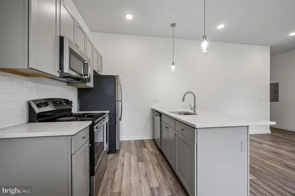a kitchen with stainless steel appliances granite countertop a sink a stove and a refrigerator
