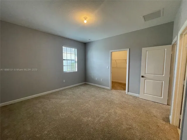 an empty room with a lamp and windows