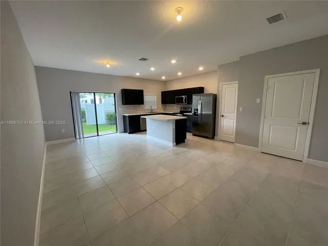 a view of a kitchen with a sink and a refrigerator