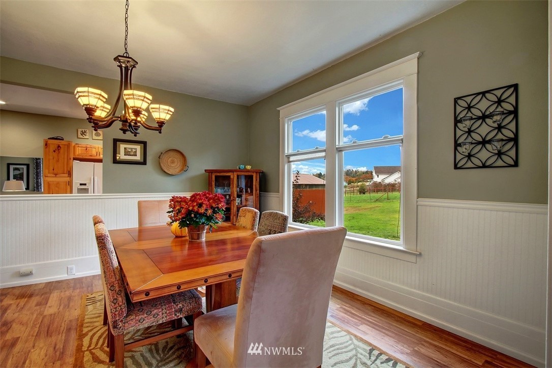 7405 Skipley Road Snohomish, WA 98290 - Photo 11 of 25 a dining room with wooden floor a chandelier a wooden table and chairs