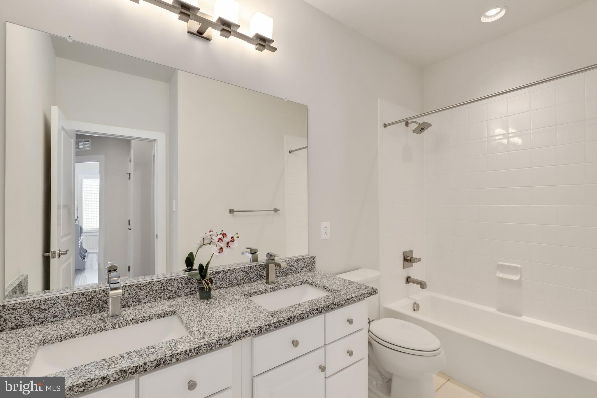 1028 Mutual Place Sandy Spring, MD 20860 - Photo 20 of 35 a bathroom with a granite countertop sink double mirror bathtub and toilet