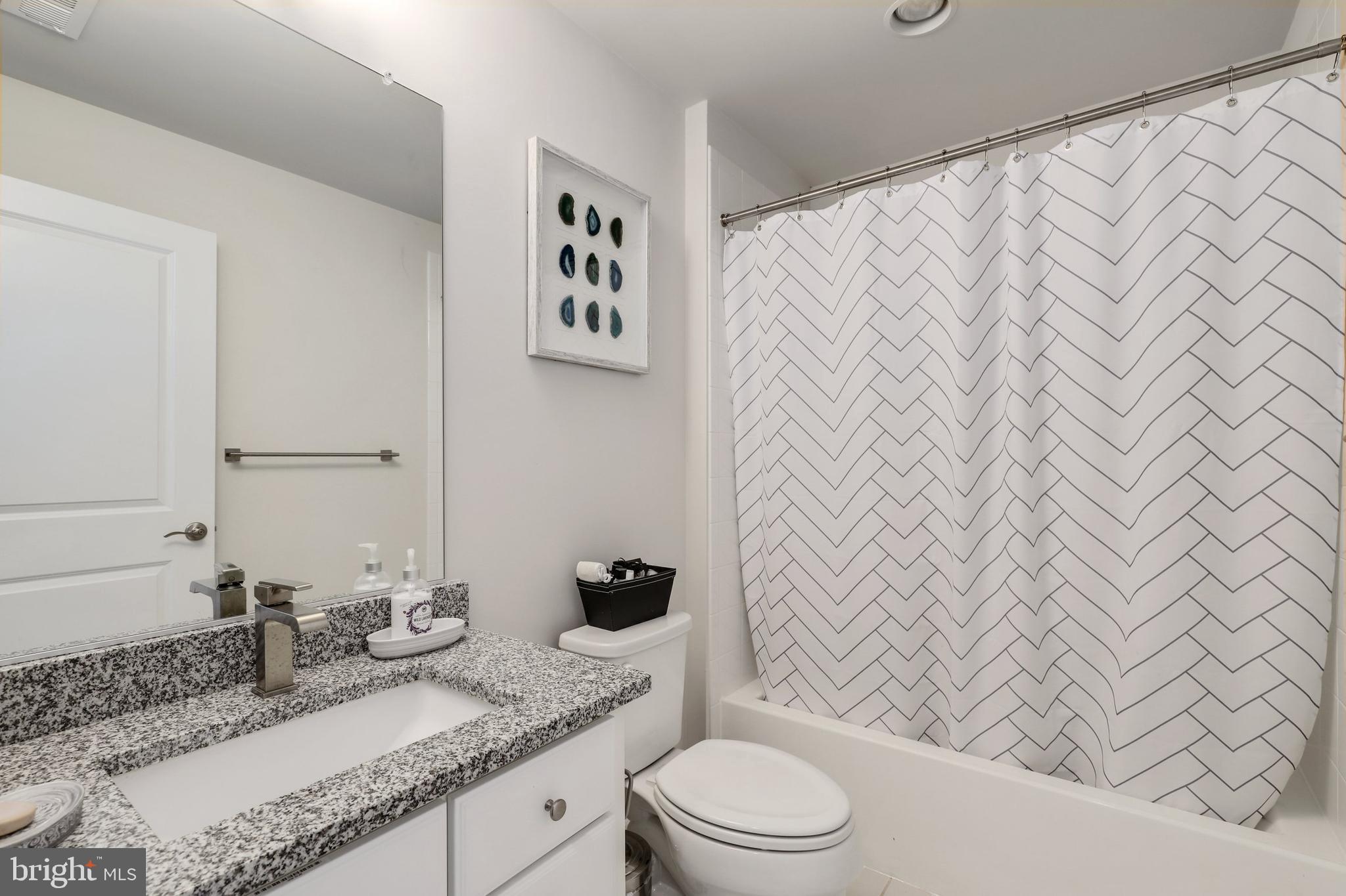 1028 Mutual Place Sandy Spring, MD 20860 - Photo 23 of 35 a bathroom with a granite countertop bathtub sink vanity mirror and toilet