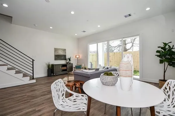 a living room with furniture a large window and a wooden floor