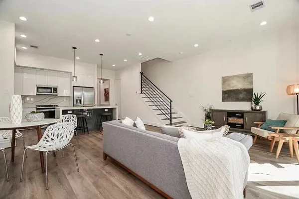 a living room with furniture kitchen view and a large window