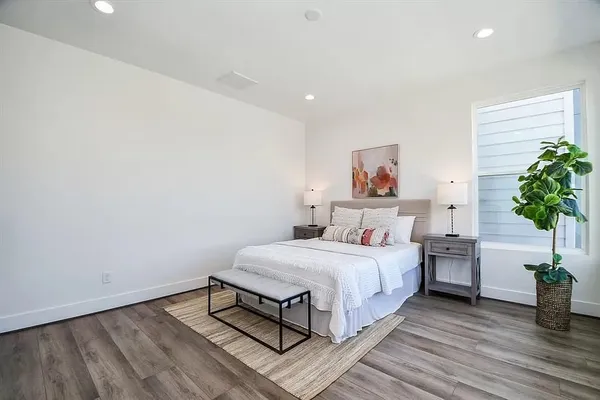 a bedroom with a bed and a potted plant