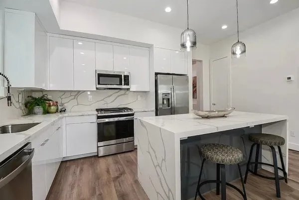 a kitchen with a stove a refrigerator and a microwave