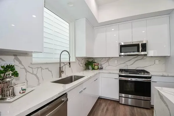 a kitchen with a sink a microwave and cabinets