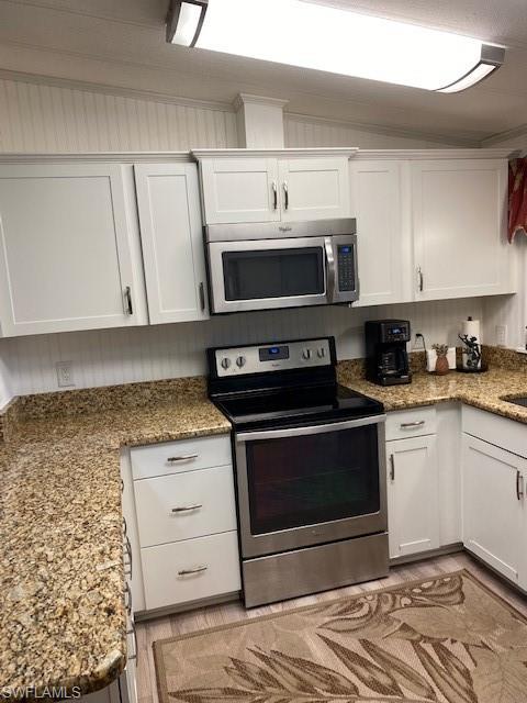 139 Rookery Road Naples, FL 34114 - Photo 21 of 37 a kitchen with granite countertop a stove a microwave a sink and cabinets
