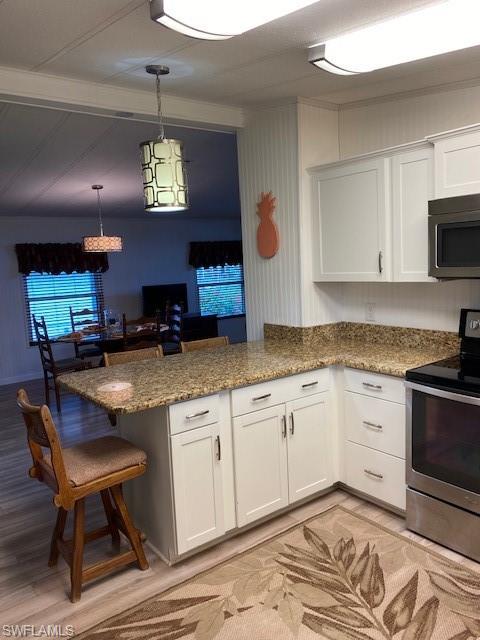 139 Rookery Road Naples, FL 34114 - Photo 22 of 37 a kitchen with stainless steel appliances granite countertop a stove a sink and a microwave