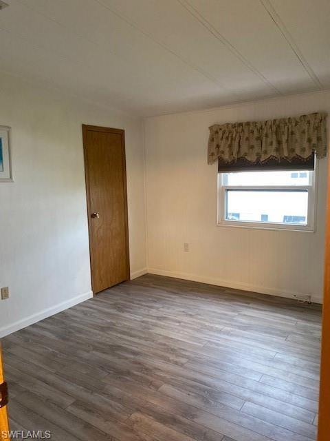 139 Rookery Road Naples, FL 34114 - Photo 24 of 37 a view of an empty room with wooden floor and a window