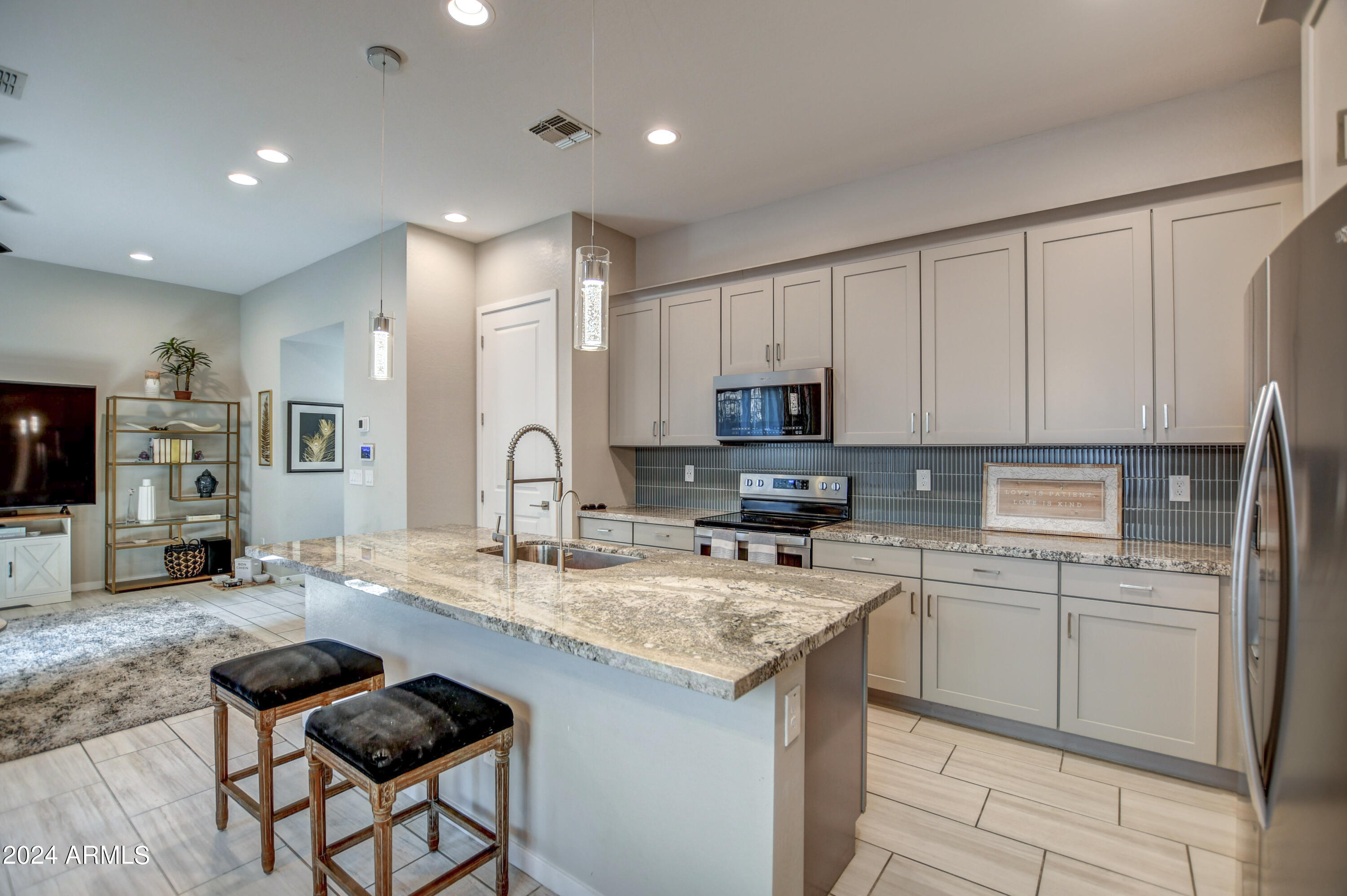901 South Smith Road, Unit 1033 Tempe, AZ 85281 - Photo 11 of 43 a kitchen with kitchen island granite countertop a stove a sink and a refrigerator