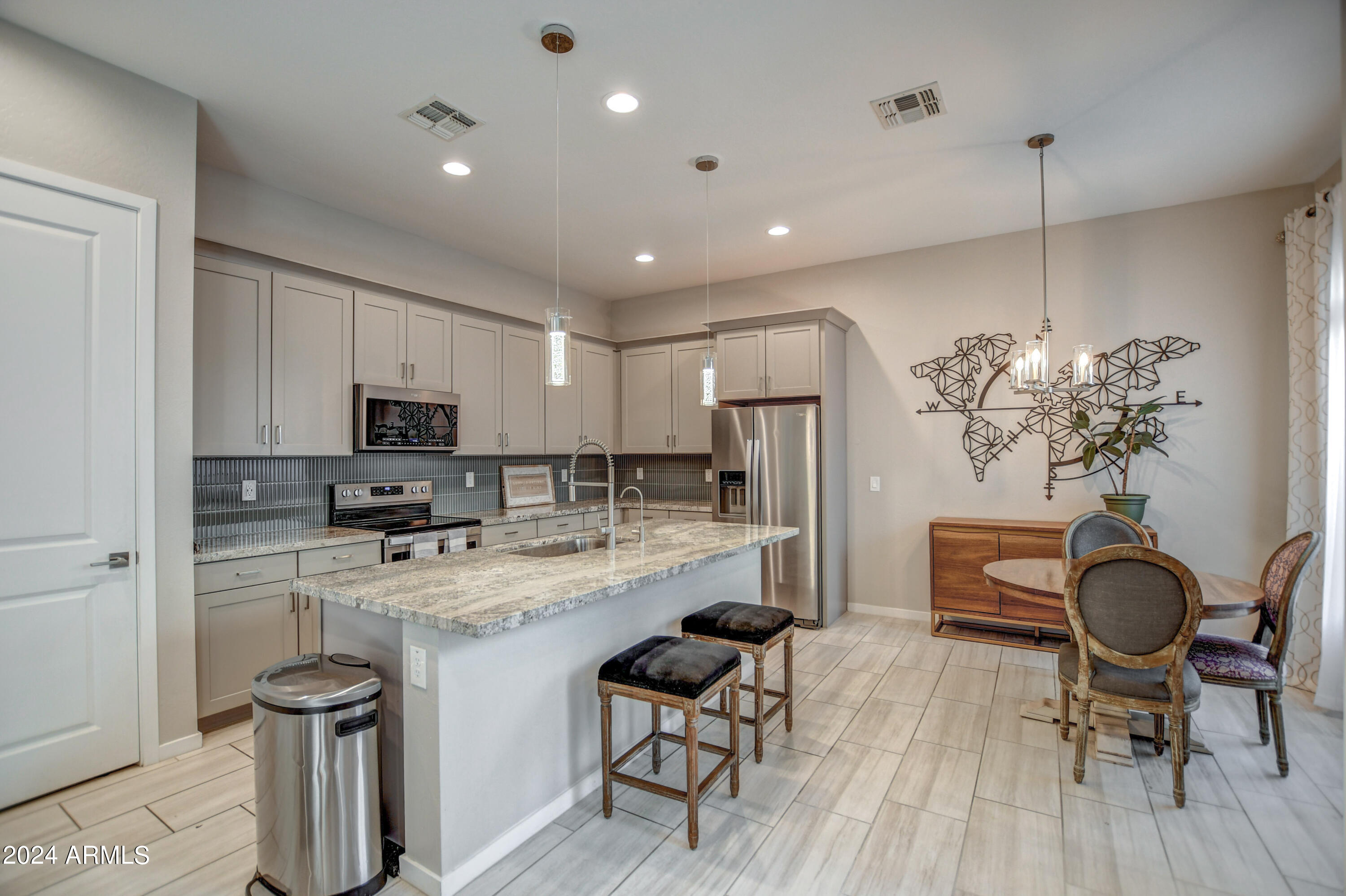 901 South Smith Road, Unit 1033 Tempe, AZ 85281 - Photo 2 of 43 a kitchen with stainless steel appliances a dining table chairs stove refrigerator and cabinets