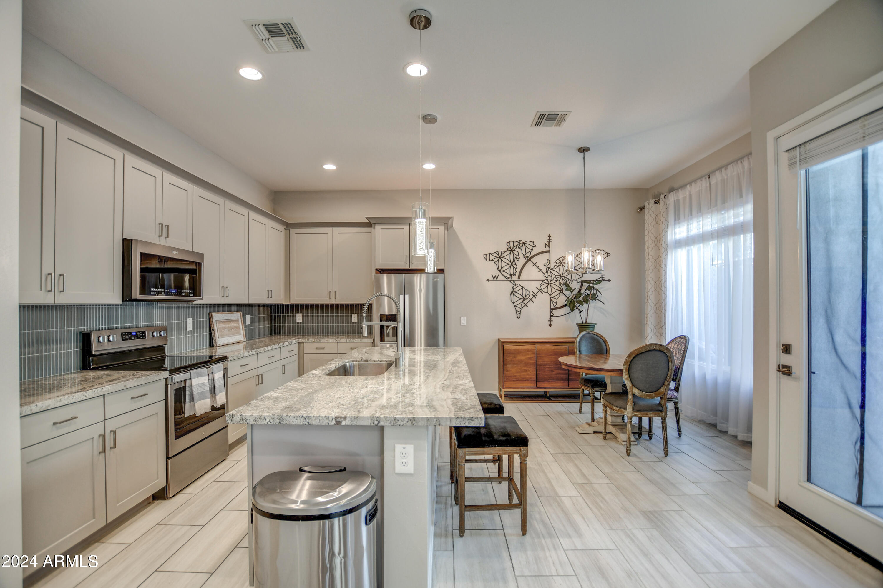 901 South Smith Road, Unit 1033 Tempe, AZ 85281 - Photo 7 of 43 a kitchen with stainless steel appliances granite countertop a stove top oven a refrigerator a sink and white cabinets with wooden floor