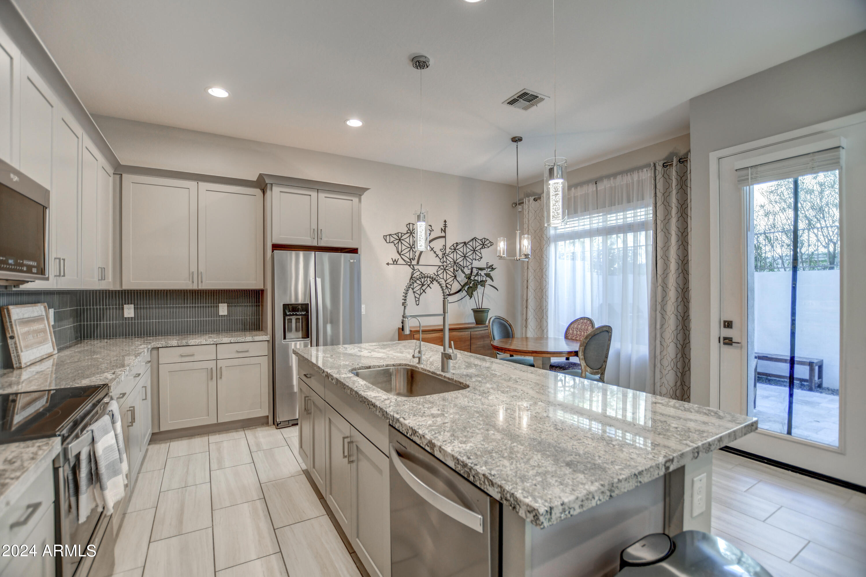 901 South Smith Road, Unit 1033 Tempe, AZ 85281 - Photo 8 of 43 a kitchen with granite countertop a sink a counter top space stainless steel appliances and cabinets