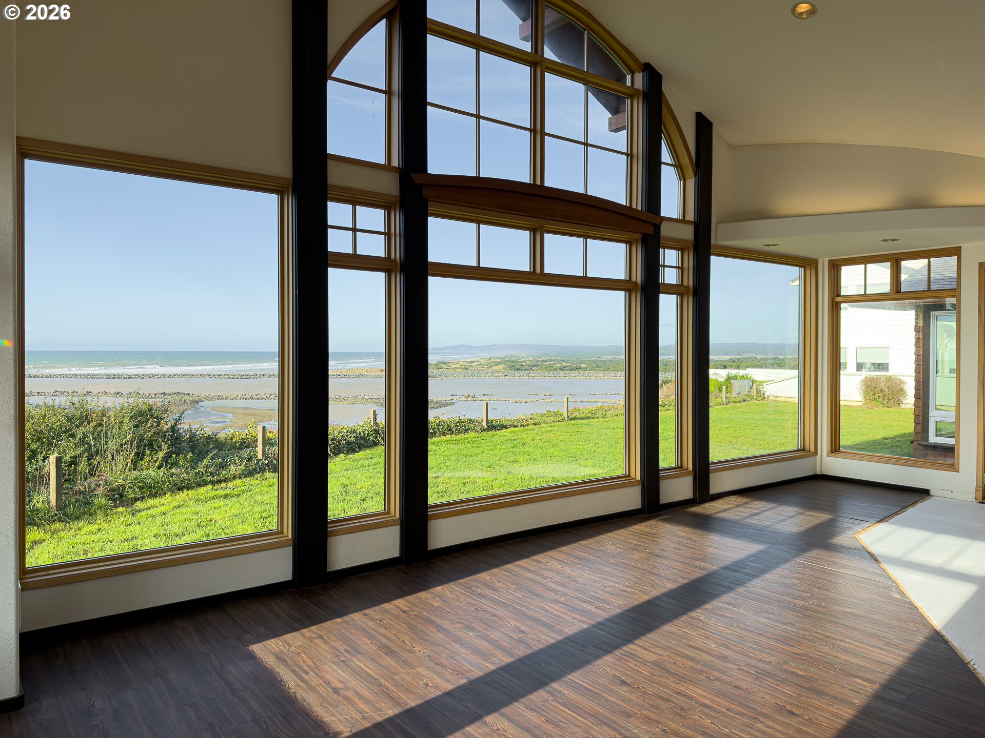 880 Ocean Drive Southwest Bandon, OR 97411 - Photo 12 of 48 a view of an empty room with wooden floor and windows
