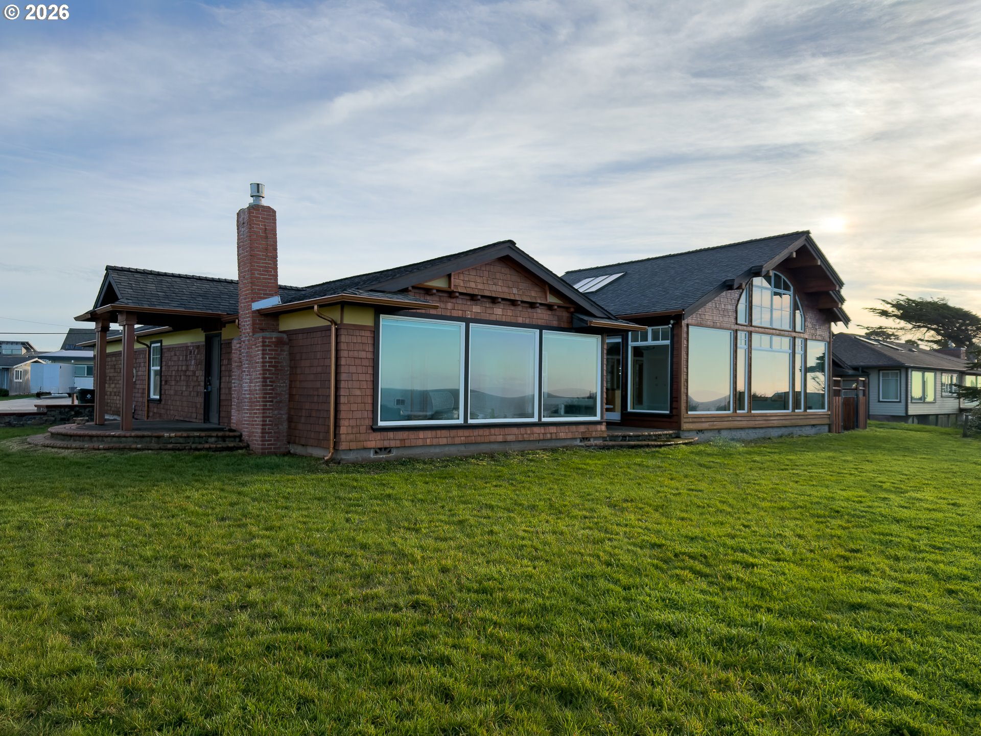 880 Ocean Drive Southwest Bandon, OR 97411 - Photo 2 of 48 a front view of a house with a garden