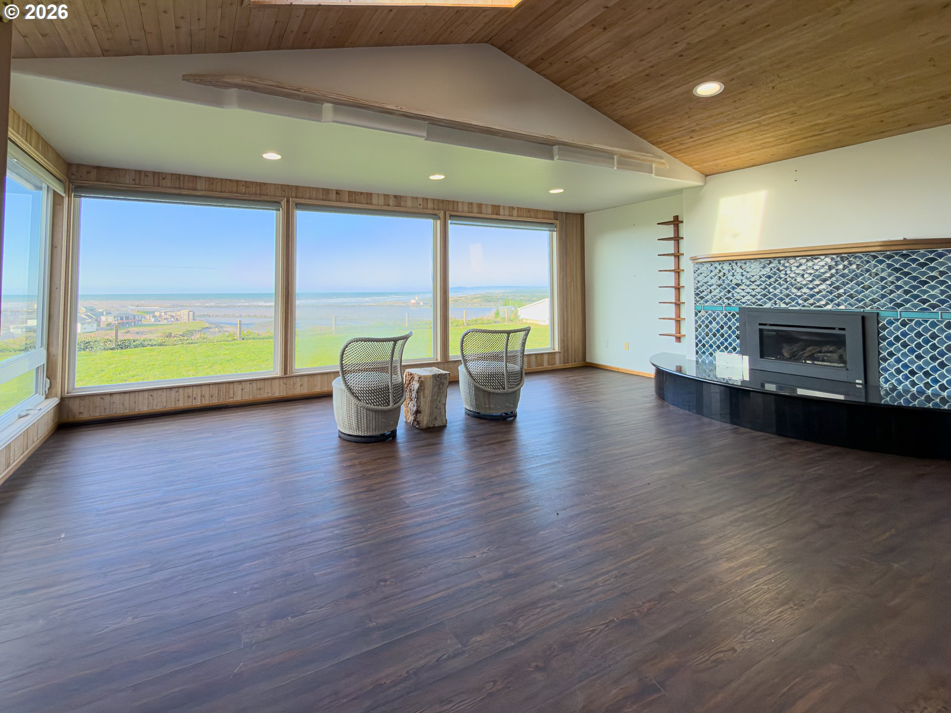 880 Ocean Drive Southwest Bandon, OR 97411 - Photo 21 of 48 an empty room with wooden floor fireplace and windows