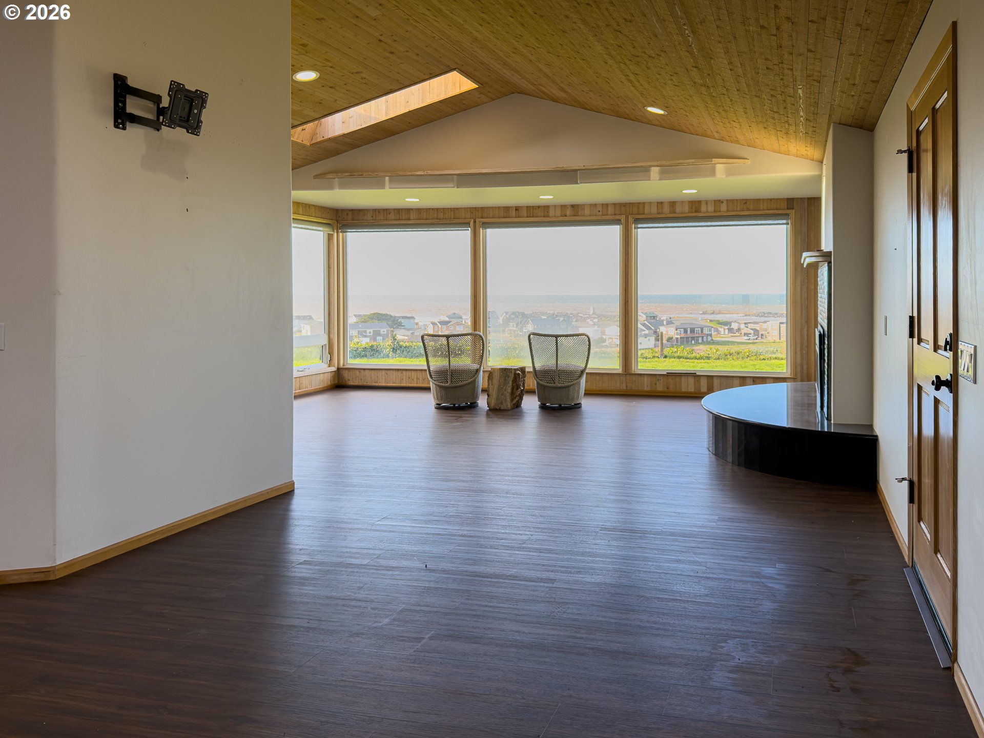 880 Ocean Drive Southwest Bandon, OR 97411 - Photo 25 of 48 an empty room with floor to ceiling window and wooden floor