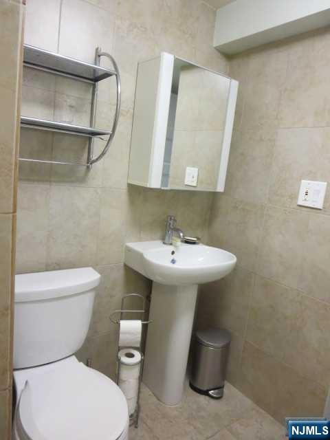 3 Old Wood Road, Unit 2 Edgewater, NJ 07020 - Photo 8 of 10 a white toilet sitting next to a bathroom sink