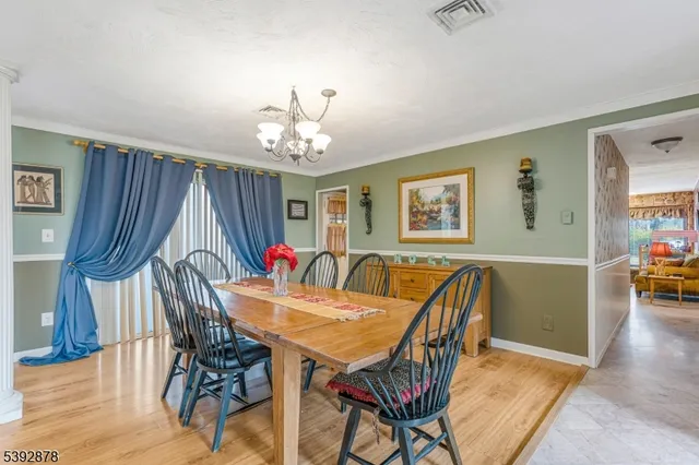a dining room with furniture a chandelier and wooden floor