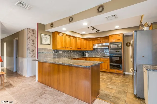 a view of a kitchen with stainless steel appliances granite countertop a refrigerator and a sink
