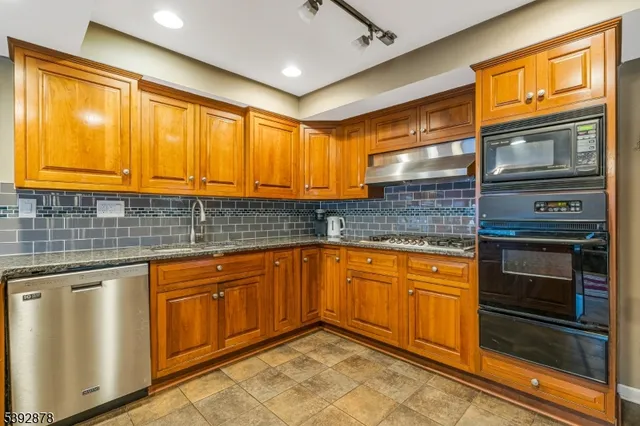 a kitchen with stainless steel appliances granite countertop a sink and cabinets