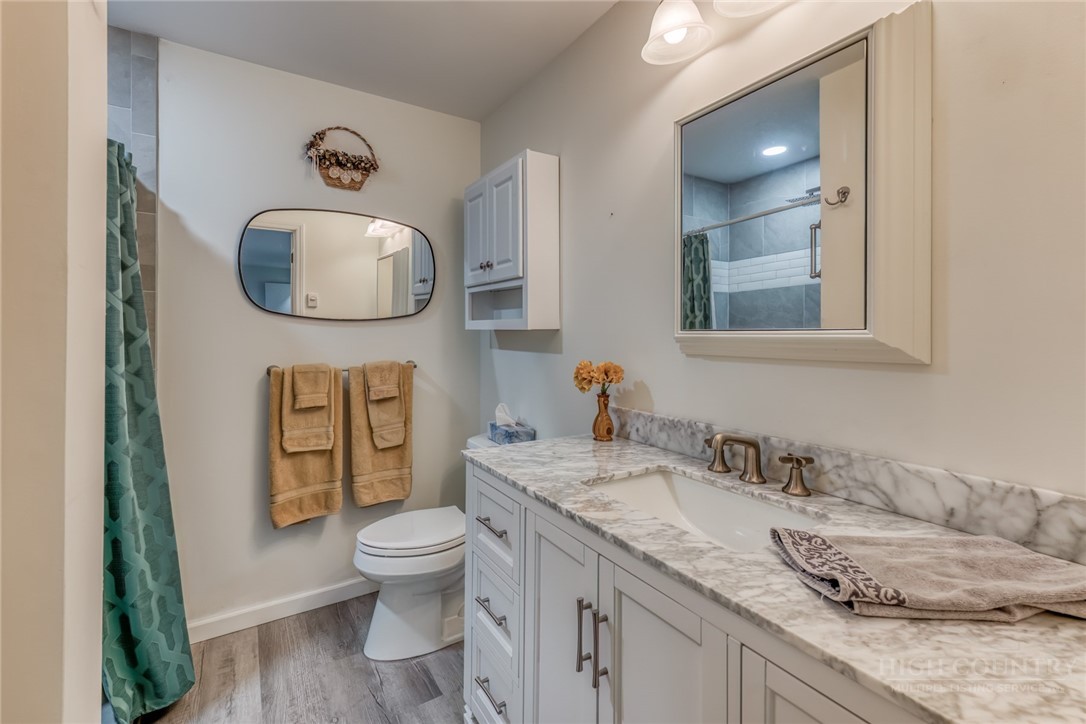 174 Spruce Pine Road Newland, NC 28657 - Photo 28 of 50 a bathroom with a granite countertop toilet sink and mirror