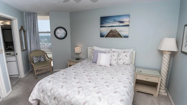 a bedroom with a bed and a lamp on dresser