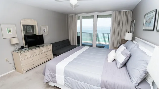 a bedroom with a bed and a flat tv screen on the dresser