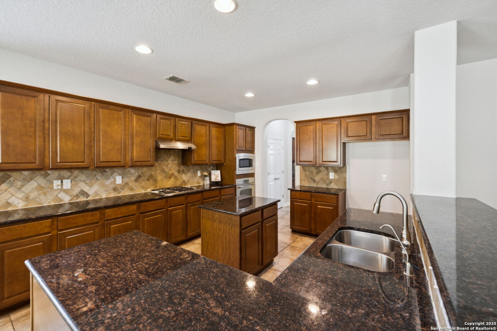 23567 7 Winds San Antonio, TX 78258 - Photo 19 of 49 a kitchen with stainless steel appliances granite countertop a sink stove and refrigerator