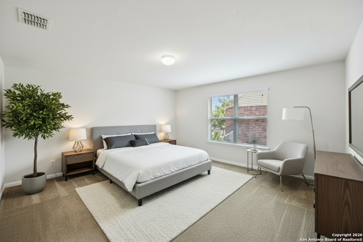 23567 7 Winds San Antonio, TX 78258 - Photo 29 of 49 a bedroom with a bed and a potted plant