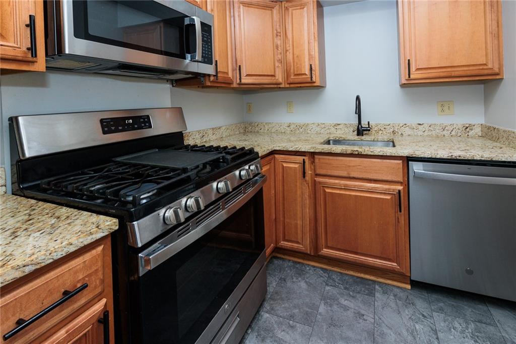 5 Bayard Road, Unit 717 Pittsburgh, PA 15213 - Photo 19 of 46 a kitchen with stainless steel appliances granite countertop a stove and a microwave