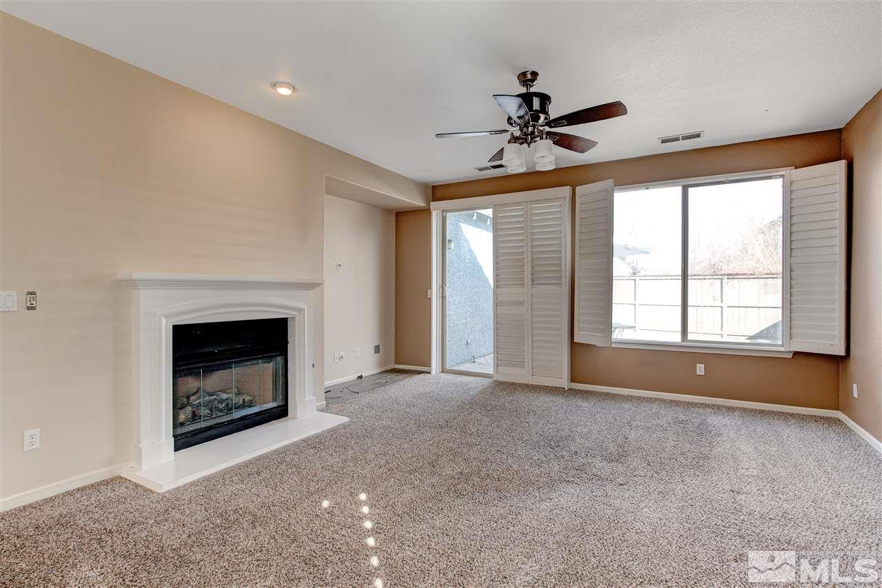475 Dartmoor Court Reno, NV 89521 - Photo 17 of 35 a view of an empty room with chandelier fan and fire place