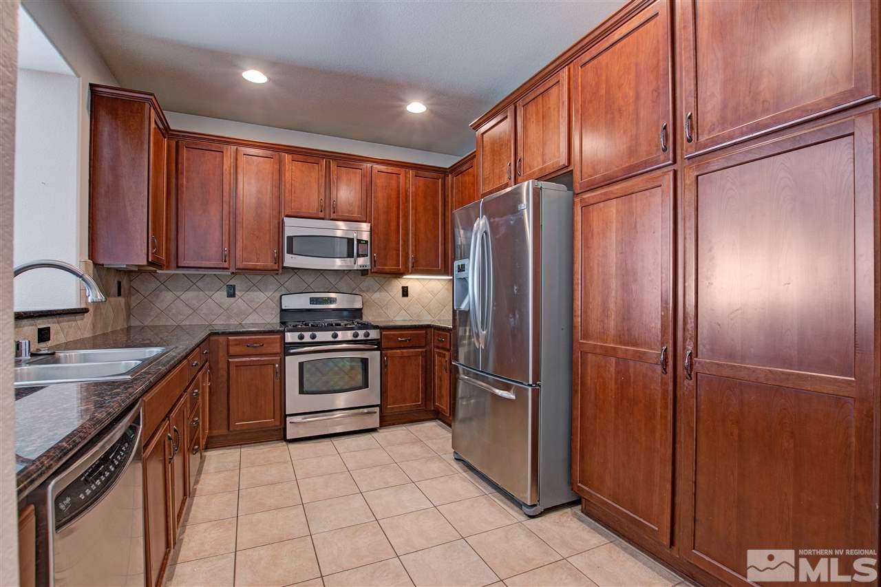 475 Dartmoor Court Reno, NV 89521 - Photo 5 of 35 a kitchen with granite countertop a refrigerator and a sink