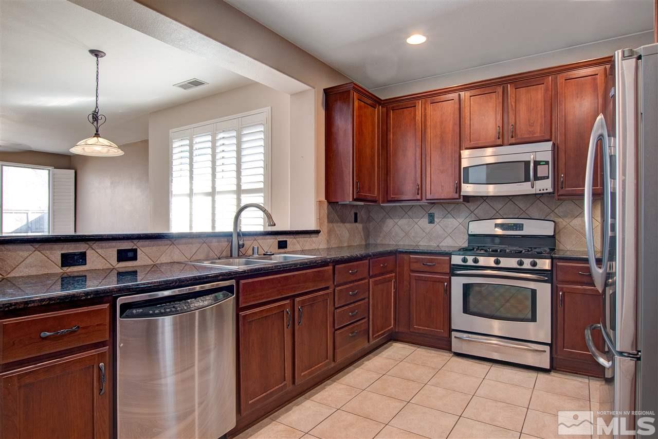 475 Dartmoor Court Reno, NV 89521 - Photo 8 of 35 a kitchen with stainless steel appliances granite countertop a sink stove and microwave