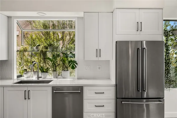 a kitchen with granite countertop white cabinets and white appliances